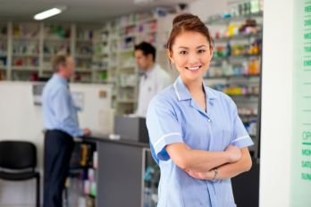 Member of staff stood in a pharmacy.