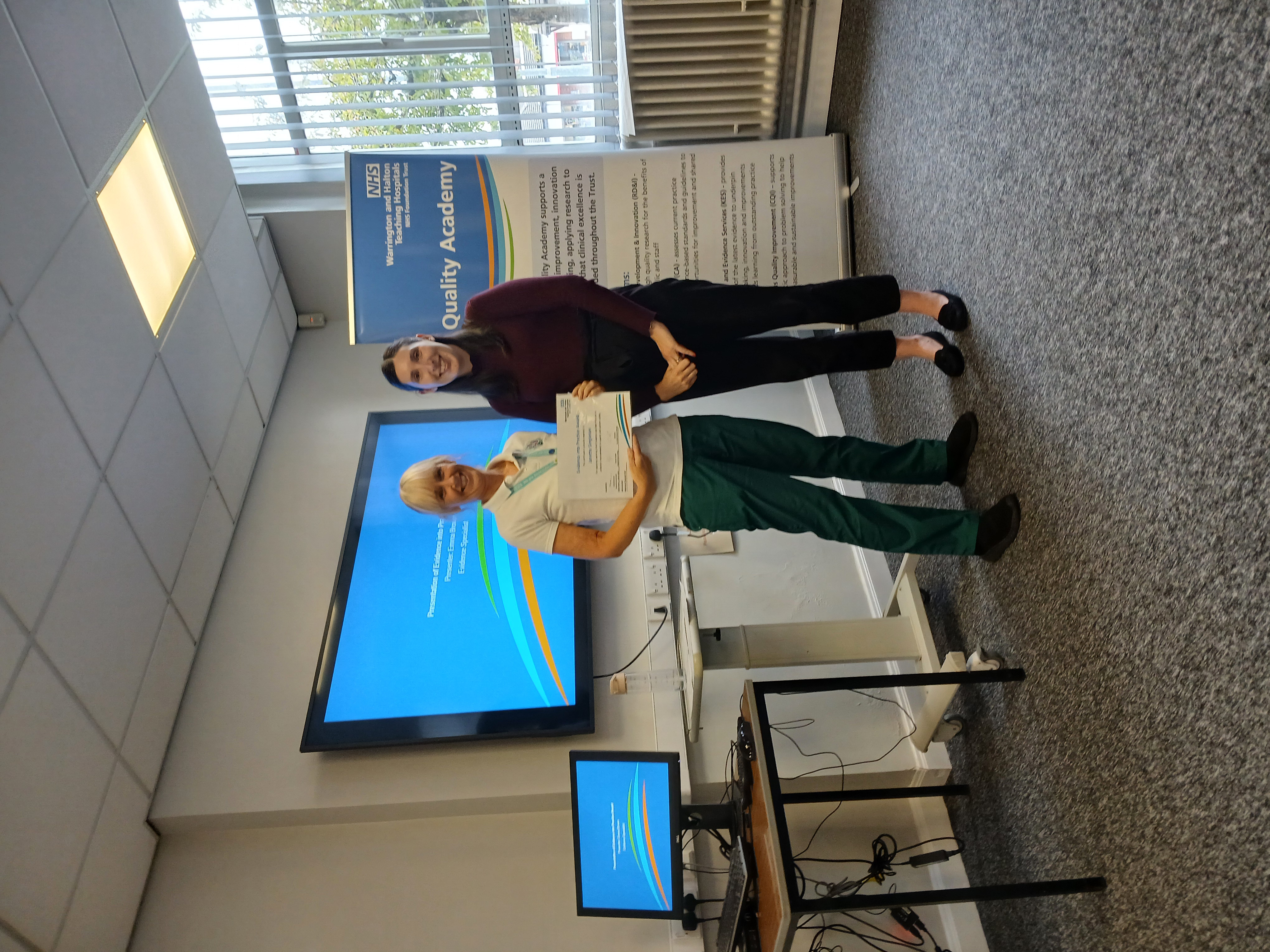 Photo of Janette Singleton, Occupational Therapy Clinical Lead, pictured receiving the WHH Evidence into Practice Award from Emma Brown, Evidence Specialist